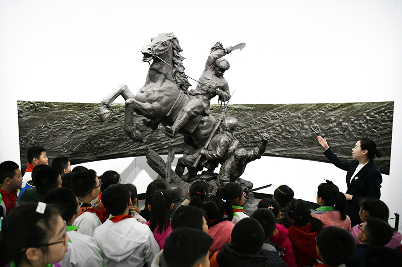 2019年4月4日，在東北烈士紀(jì)念館，學(xué)生們?cè)诼犞v解員講解。